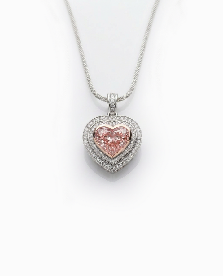 Fancy Vivid Pink heart-shape lab-grown diamond pendant with 14K rose gold bezel and double diamond pavé heart frame in white gold — studio view