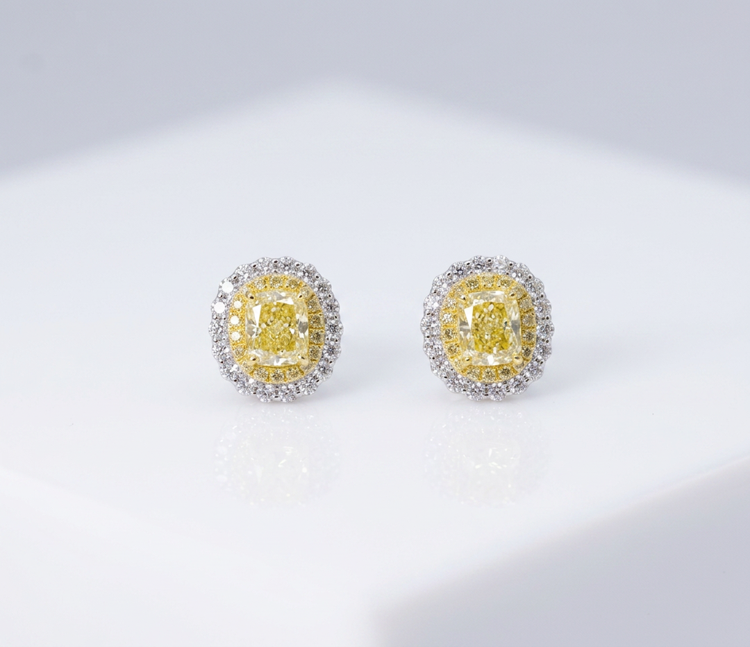 Fancy Vivid Yellow cushion-cut lab-grown diamond stud earrings with double micro-pavé halos in 14K white gold — studio view