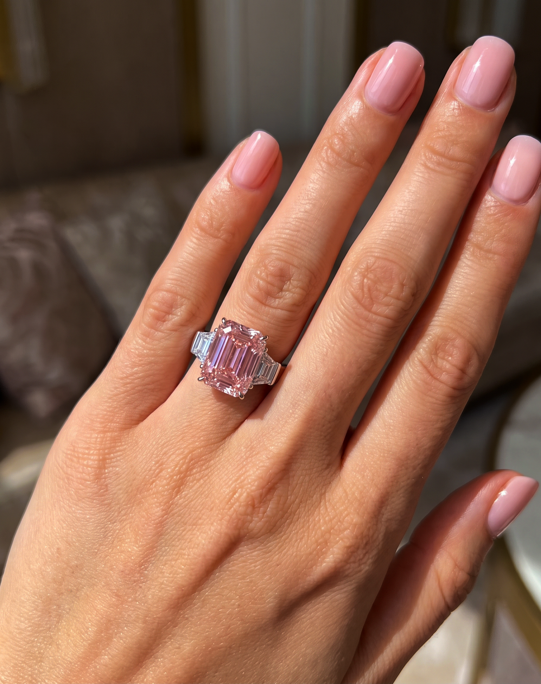 Fancy Vivid Pink emerald-cut lab-grown diamond three-stone ring worn on the hand
