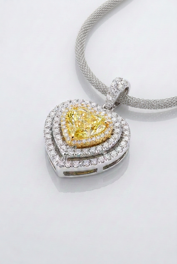 2 ct Fancy Vivid Yellow heart-shape lab-grown diamond pendant with yellow gold frame and double white pavé halo in 14K white gold — studio view