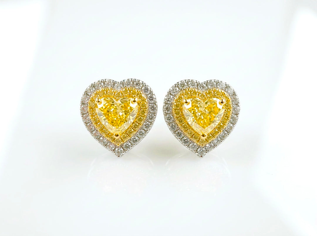 Fancy Vivid Yellow heart-shape lab-grown diamond stud earrings with two-tone double pavé halos in 14K white gold — studio view