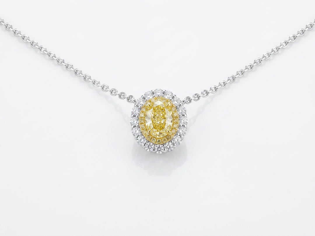 Fancy Vivid Yellow oval lab-grown diamond pendant with two-tone double pavé halo on a white gold chain — studio view