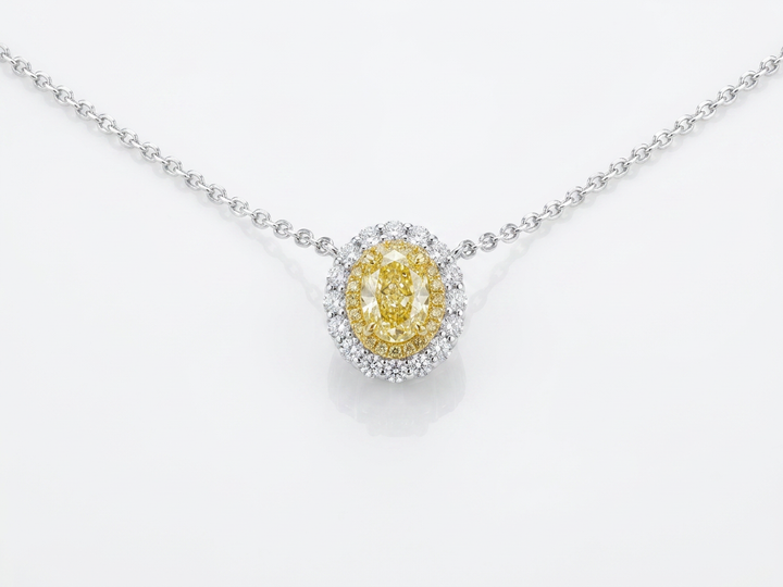 Fancy Vivid Yellow oval lab-grown diamond pendant with two-tone double pavé halo on a white gold chain — studio view