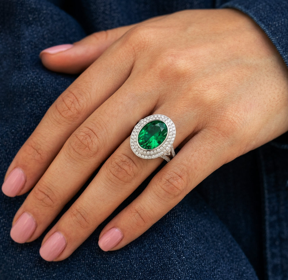 Oval lab-grown emerald double halo pavé ring worn on the hand