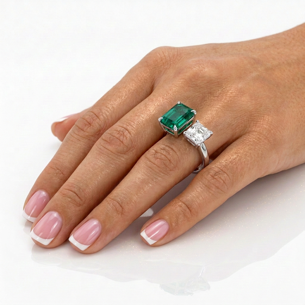 Toi et Moi lab-grown emerald and Asscher diamond ring worn on the hand